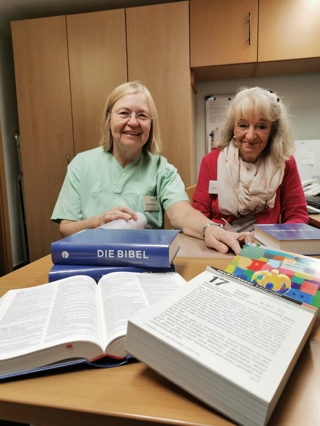 Teamarbeit: (von links) Marlies Rombald von den Grünen Damen und Christine Sangen vom Büchereiteam schlagen gemeinsam die neuen Bibeln ein.